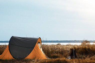 Kamp çadırı doğa ve gölün arka planında yeşil. Seyahat, turizm, kamp konsepti.