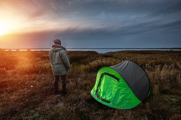 Un homme barbu près d'une tente de camping en vert sur le fond de la nature et du lac. Le concept de voyage, tourisme, camping . — Photo