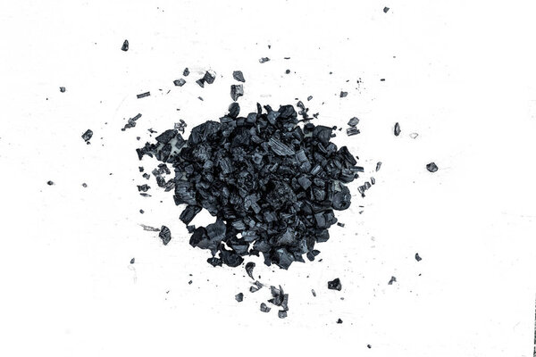 A pile of dark coal on a white background, coal mining, fossil fuel, environmental pollution.