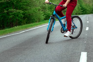 Eşofmanlı bir adam ormanda bir yolda bir bisikletin yanında duruyor. Sağlıklı yaşam tarzı konsepti, kardiyo eğitimi. Kopyalama alanı