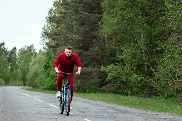 Мужчина Спортивном Костюме Велосипеде Едет Дороге Лесу Концепция Здорового Образа — стоковое фото