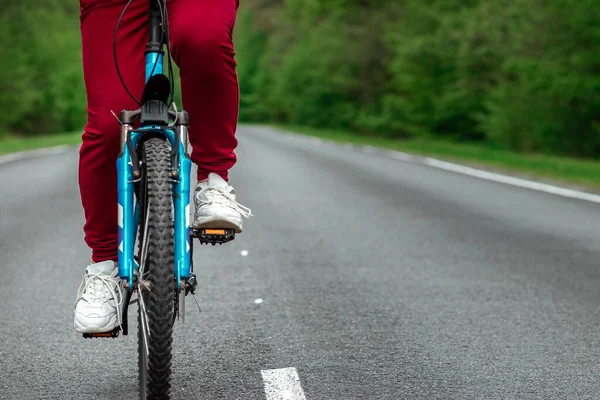 自転車のペダルの上の脚を閉じると 森の中で道路に乗る 健康的なライフスタイル 心臓トレーニングの概念 コピースペース — ストック写真