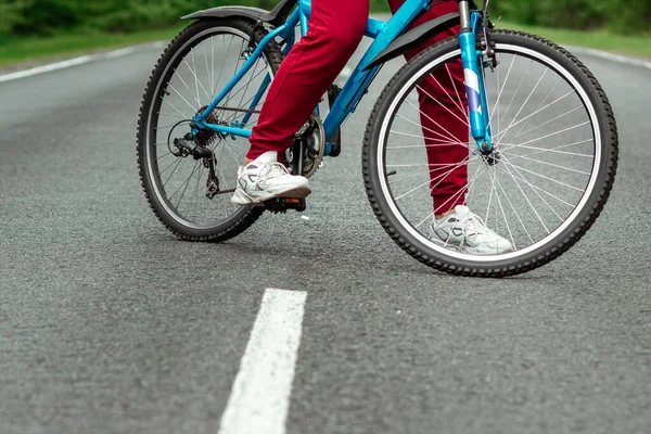 自転車のペダルの上の脚を閉じると 森の中で道路に乗る 健康的なライフスタイル 心臓トレーニングの概念 コピースペース — ストック写真