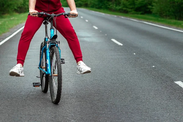 幸せな男性の足で自転車に乗る 森の中の道路 健康的なライフスタイル 心臓トレーニングの概念 コピースペース — ストック写真