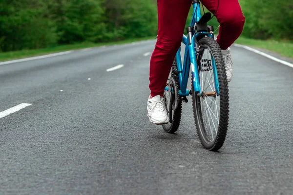 Piernas Sobre Los Pedales Una Bicicleta Cerca Montando Una Carretera —  Fotos de Stock