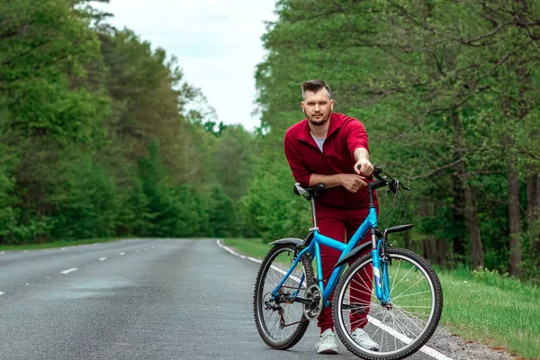 Mężczyzna Dresie Stoi Obok Roweru Drodze Lesie Koncepcja Zdrowego Stylu — Zdjęcie stockowe