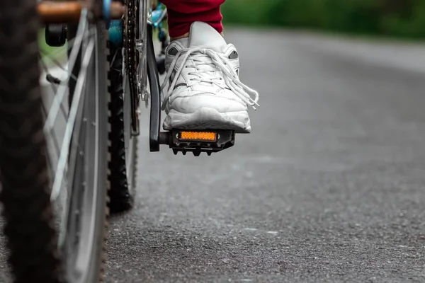 Piernas Sobre Los Pedales Una Bicicleta Cerca Montando Una Carretera —  Fotos de Stock