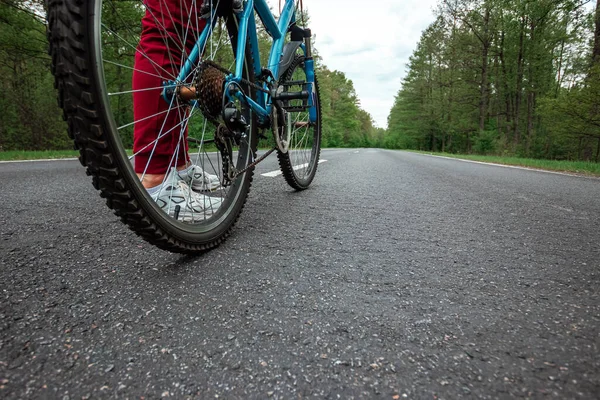 自転車のペダルの上の脚を閉じると 森の中で道路に乗る 健康的なライフスタイル 心臓トレーニングの概念 コピースペース — ストック写真