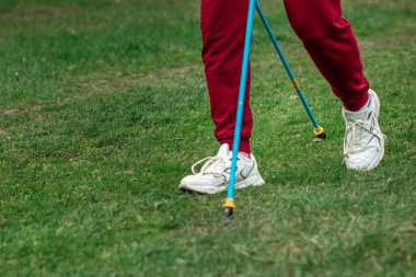 İskandinav yürüyüşü, sopalar, bacaklar. Sağlıklı yaşam tarzı konsepti, kardiyo eğitimi. Kopyalama alanı
