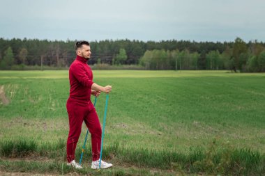 Eşofmanlı bir adam İskandinav yürüyüşü yapıyor. Sağlıklı yaşam tarzı konsepti, kardiyo eğitimi. Kopyalama alanı