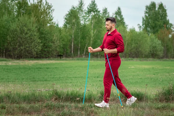 Een Man Een Trainingspak Bezig Met Nordic Walking Het Concept — Stockfoto