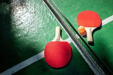 Spor oyunları konsepti, sağlıklı yaşam tarzı. Masa tenisi ve turuncu toplar için raketler. Boşluğu kopyala, yumuşak odak