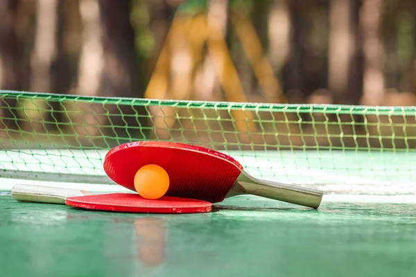 The concept of sports games, healthy lifestyle. Rackets for for ping pong and orange balls. Copy space, soft focus