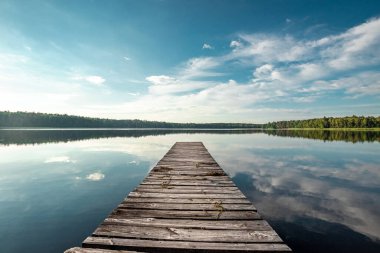 Wooden pier on the background of a beautiful lake summer dawn landscape. Copy space clipart
