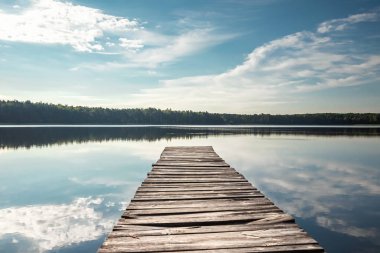 Güzel bir gölün arka planında ahşap iskele yaz şafağı manzarası. Boşluğu kopyala