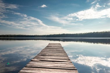 Güzel bir gölün arka planında ahşap iskele yaz şafağı manzarası. Boşluğu kopyala