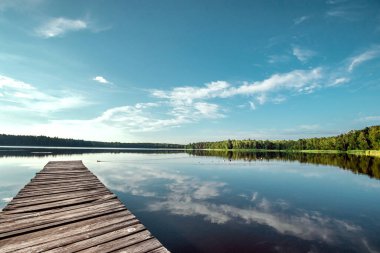 Güzel bir gölün arka planında ahşap iskele yaz şafağı manzarası. Boşluğu kopyala