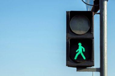 Gökyüzüne karşı yeşil yaya trafik ışığı