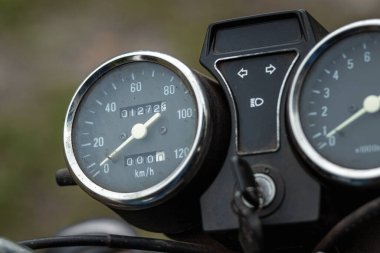 Motosiklet hız göstergesi yakın çekim, motorcu yolda gidiyor.