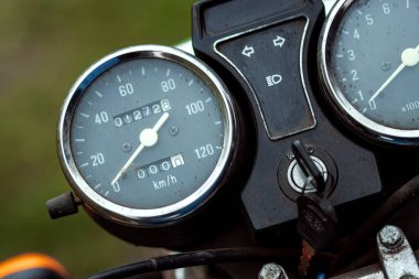 Motosiklet hız göstergesi yakın çekim, motorcu yolda gidiyor.