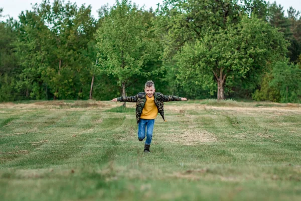 Niño Corre Por Campo Con Los Brazos Extendidos Sobre Fondo —  Fotos de Stock