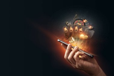 Yaratıcılık geçmişi, online kumarhane, bir adamın elinde oyun kartları, rulet fişleri, siyah-altın arka planı olan bir akıllı telefon. İnternet kumar konsepti. Boşluğu kopyala.