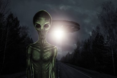 Uçan dairenin arka planında siyah camdan gözleri olan yeşil bir uzaylı. UFO konsepti, uzaylılar, dünya dışı uygarlıkla temas..