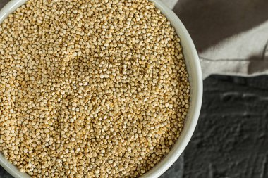 Quinoa tohumları bir kase ve kaşık. Sağlıklı, protein açısından zengin karbonhidratlar. Rustik ve koyu arka plan