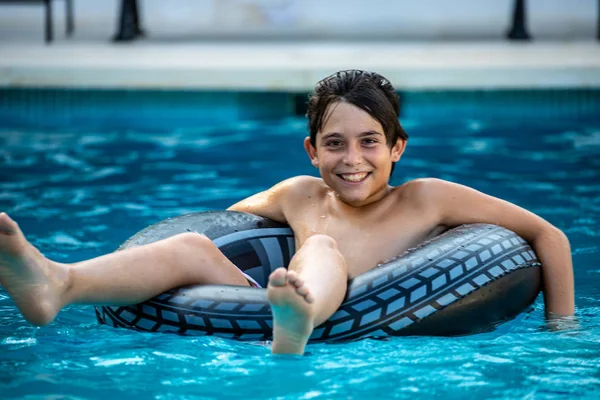 歳の少年が夏の間に彼の家のプールで遊ぶ — ストック写真