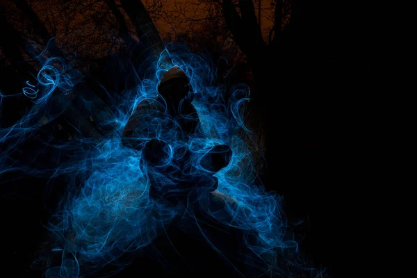 Зловещий Персонаж Дереве Сфотографированный Вспышки Фонариком Окруженный Синими Огнями — стоковое фото