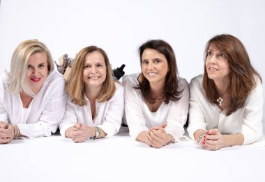 Dört arkadaş beyaz arka plan ile yerde yatarken bir stüdyoda fotoğraf oturum.