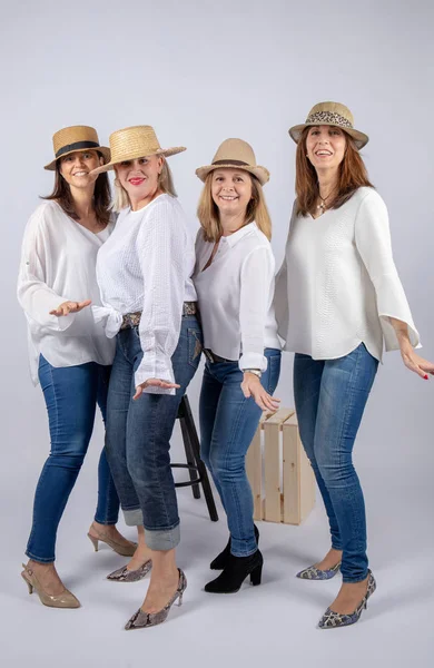 Diversion of four friends in a photographic studio in foot and with hat.