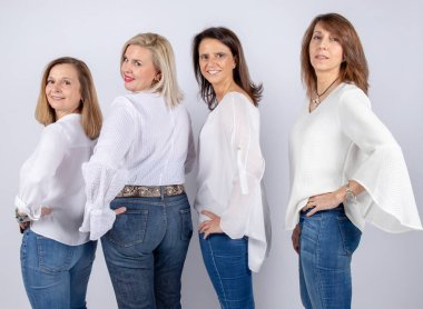 Grup 4 kadın, arkadaş, beyaz arka plan ile bir stüdyoda fotoğraf oturumunda eğleniyor orta yaşlı