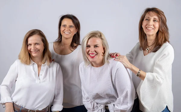 Grup 4 kadın, arkadaş, beyaz arka plan ile bir stüdyoda fotoğraf oturumunda eğleniyor orta yaşlı