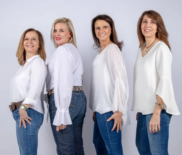 Grup 4 kadın, arkadaş, beyaz arka plan ile bir stüdyoda fotoğraf oturumunda eğleniyor orta yaşlı