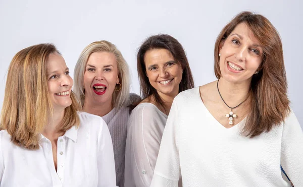 Grup 4 kadın, arkadaş, beyaz arka plan ile bir stüdyoda fotoğraf oturumunda eğleniyor orta yaşlı