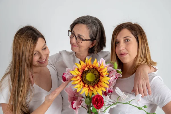 Мати і дві сестри-близнючки насолоджуються дуже смішним ставленням з великим соняшником в руках — стокове фото