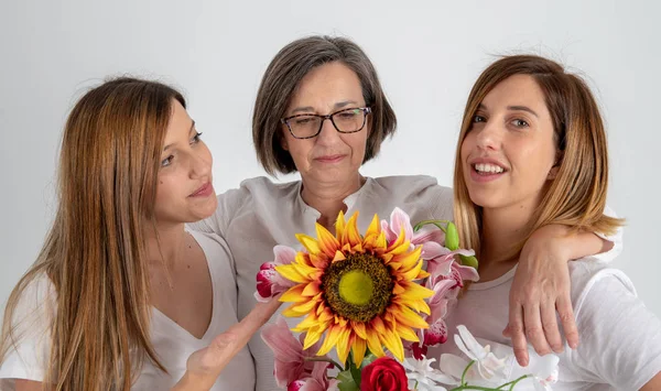 Anne ve ikiz kız kardeşler ellerinde büyük bir ayçiçeği ile çok komik bir tutum zevk — Stok fotoğraf