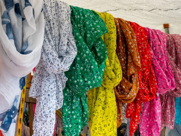 Image of some foulards in different colors hanging in a flea market — Stock Photo, Image