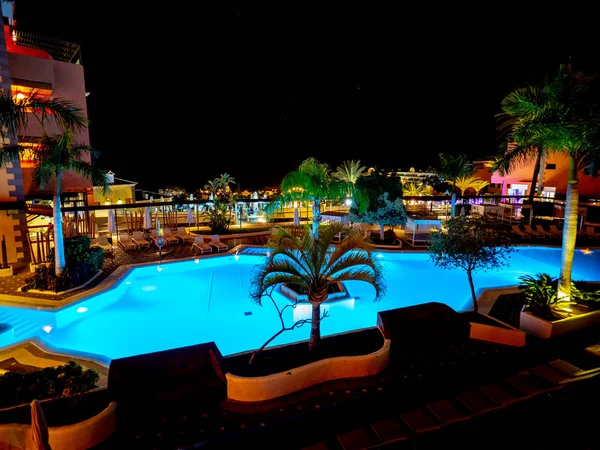 Piscina de um hotel visto à noite e iluminado com suas próprias luzes . — Fotografia de Stock