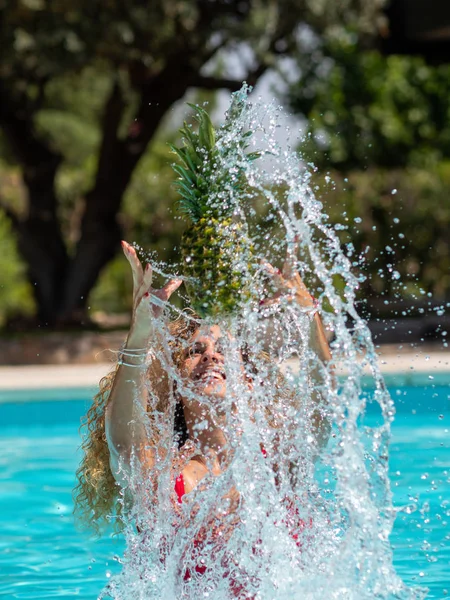 Kaukaski blond dziewczyna gra z ananasem w basenie. — Zdjęcie stockowe