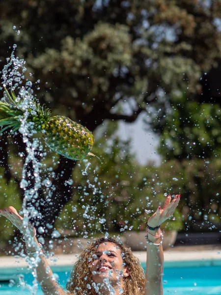 Kafkas sarışın kız havuzda bir ananas ile oynuyor. — Stok fotoğraf