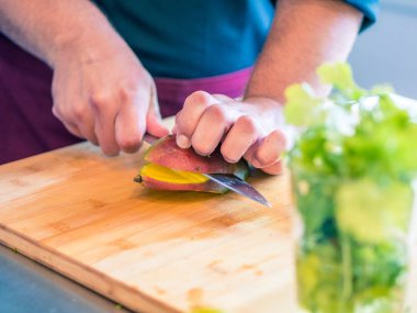 Modern mutfakta sebze ve meyve hazırlayan insanın ellerinin yakın çekim.