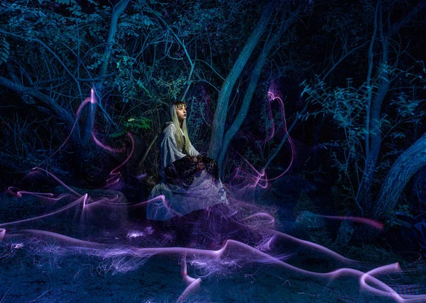 Fotografia notturna, lightpainting, raffigurante un modello nel fiume con ombre fatte con lanterne sul fiume . — Foto Stock