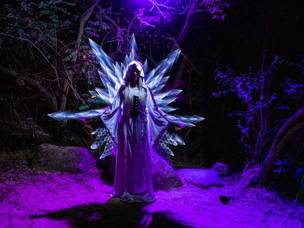 Mujer en el bosque con espadas saliendo de su espalda hechas con luz. Técnica Lightpainting — Foto de Stock