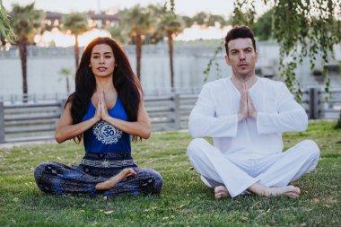 Kafkas adam ve Latin kadın Madrid'de bir parkta meditasyon. Çift konsantrasyon ve gevşeme