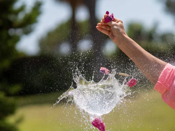 Secuencia en varias fotos del lanzamiento de un dardo contra un globo lleno de agua y su posterior explosión . —  Fotos de Stock