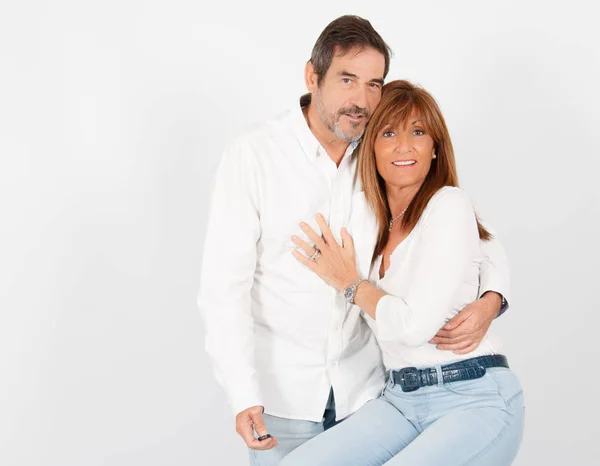 Un couple adulte de 50 ans pose dans un studio photographique d'une manière joyeuse avec un fond blanc . — Photo