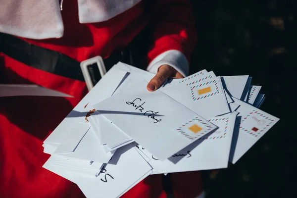 Mamá Noel mirando y organizando cartas navideñas en medio de la calle Imagen De Stock