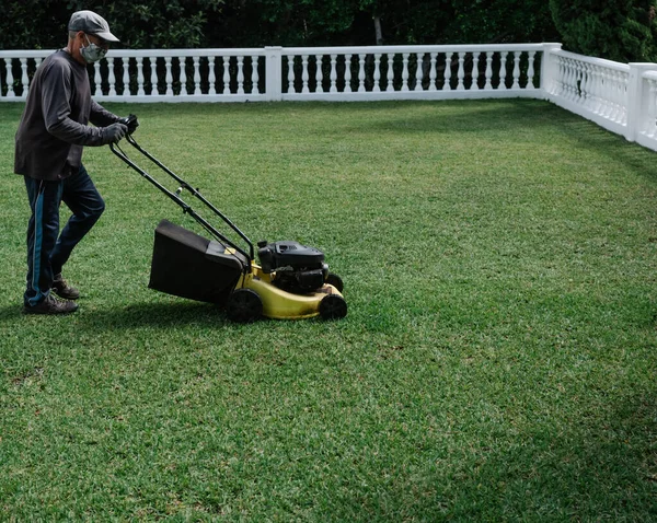 Persona Con Máscara Está Preparando Jardín Con Una Segadora Eléctrica —  Fotos de Stock